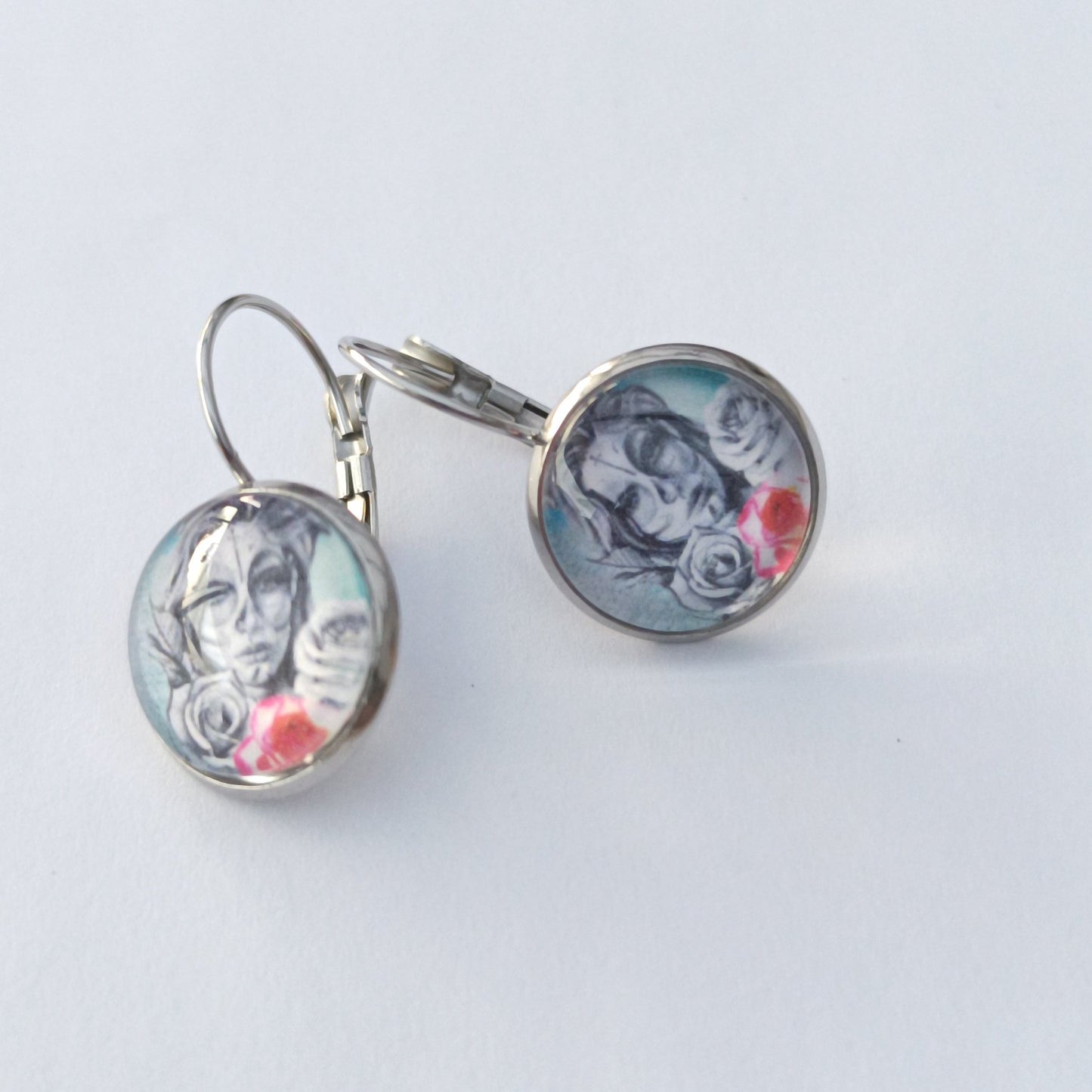 Boucle d'oreille en cabochon de verre. Motif femme aux roses
